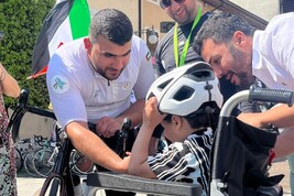 Il campione Alaa al-Dali (s) capitano dei Gaza Sunbirds, regala il caschetto a un piccolo palestinese cui sono state amputate le gambe