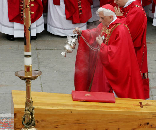 Joseph Ratzinger asperge con incenzo la bara di Giovanni Paolo II posta su di un tappeto sul sagrato della Basilica di San Pietro l'8 aprile del 2005