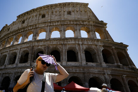 Turista tenta se proteger do calor diante do Coliseu de Roma