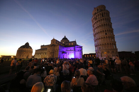 Multidão reunida diante de torre de Pisa