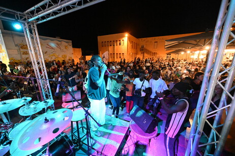 Migrantes dançam na festa da Madonna di Porto Salvo, padroeira de Lampedusa (Foto: Ciro Fusco/ANSA)