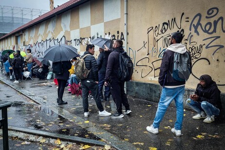 Estrangeiros aguardam em fila para agência de imigração em Turim