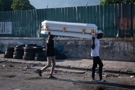 Homens carregam caixão em rua de Porto Príncipe, capital do Haiti, em meio a onda de violência