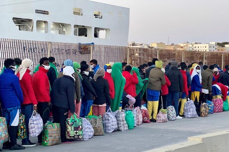 Migrantes em fila em Lampedusa, porta de entrada para deslocados internacionais na Itália