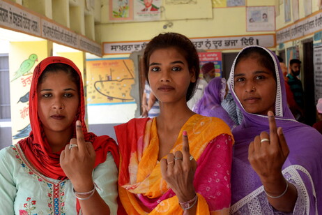 Eleitoras mostram marca de tinta no dedo após votação na Índia