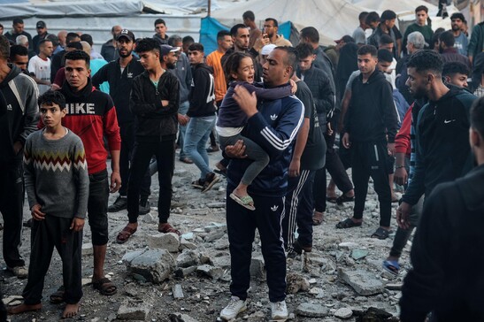 Homem segura criança chorando após ataque israelense contra escola em Gaza