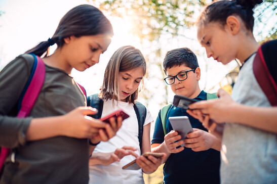 Studenti intenti a guardare telefonini foto iStock.