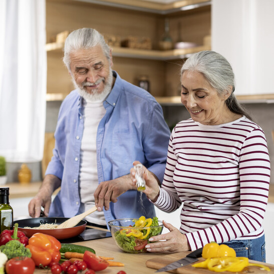 Una coppia di anziani cucina assieme. dieta benessere salute Attestazione: Prostock-Studio - iStock