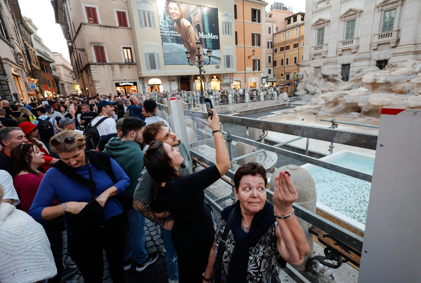 Fontana di Trevi senza acqua per il restauro, turisti lanciano monete in una vasca