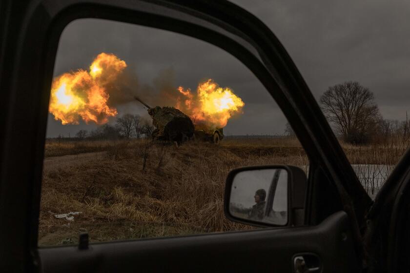 Soldado ucraniano refletido em retrovisor acompanha disparo em direção a alvos russos em Donetsk