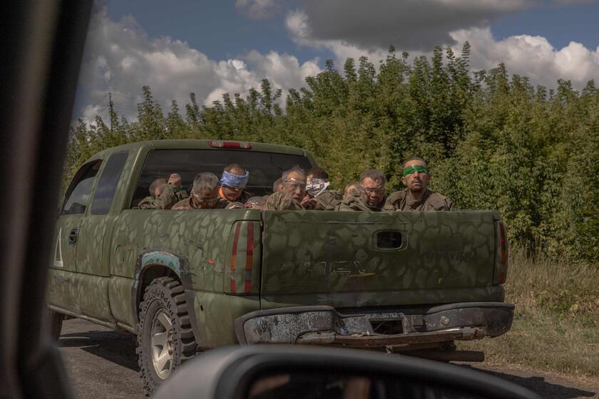 Um veículo militar ucraniano sai da direção da fronteira com a Rússia carregando homens vendados