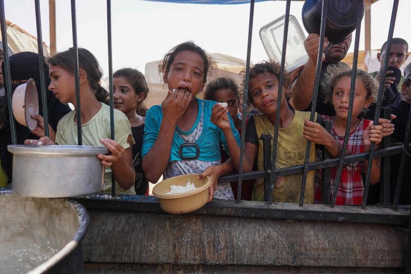 Palestinos recebem comida como parte de uma iniciativa voluntária em Khan Yunis