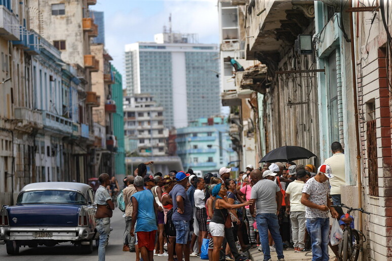 Gente ante una tienda para comprar antes de que se pudran los alimentos. © ANSA/EPA