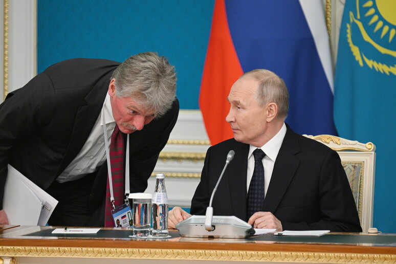 Kremlin spokesman Dmitry Peskov (L) talks to Russian President Vladimir Putin © ANSA/EPA