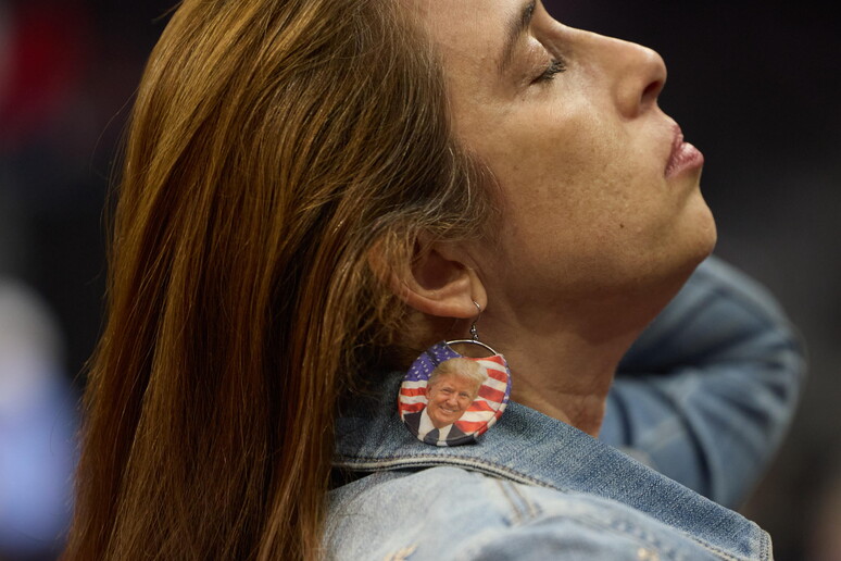 Una mujer usa aretes de Trump mientras esperaba que el expresidente hablase en un foro en Nevada. - TODOS LOS DERECHOS RESERVADOS