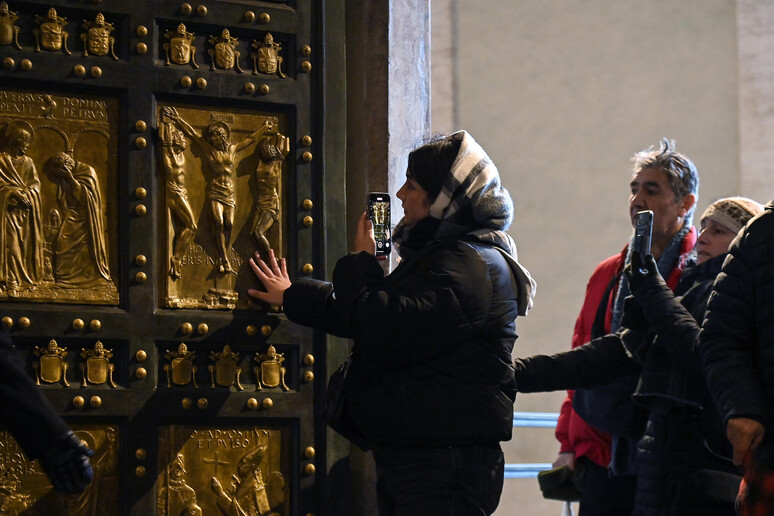 Giubileo: gruppi di pellegrini attraversano la Porta Santa - RIPRODUZIONE RISERVATA