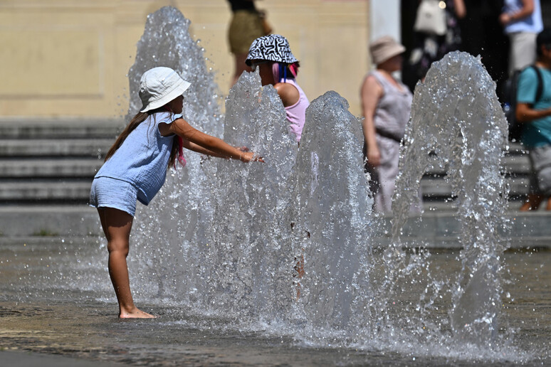 Una persona si rinfresca con l 'acqua a Genova, archivio - RIPRODUZIONE RISERVATA