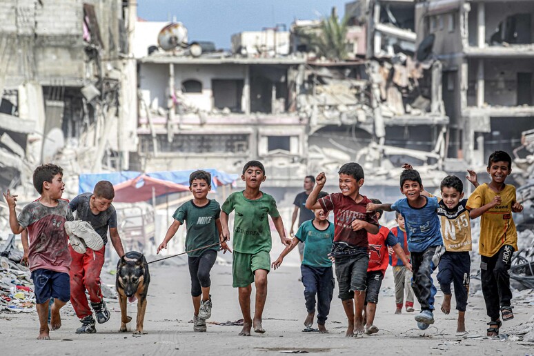 Crianças caminham perto de prédios destruídos em Khan Younis, na Faixa de Gaza © ANSA/AFP