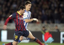 Lionel Messi (s) contrastato da Jon Gaztanaga della Real Sociedad